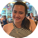 Headshot of Justine Ileto, Class of 2022, a woman with long dark hair in a ponytail, who wears a striped blouse.