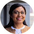 Headshot of NU student Cecilia, a woman with long dark hair who is wearing glasses and a tan sweater.