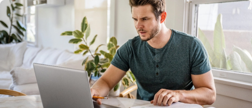 man works on a laptop in a living room