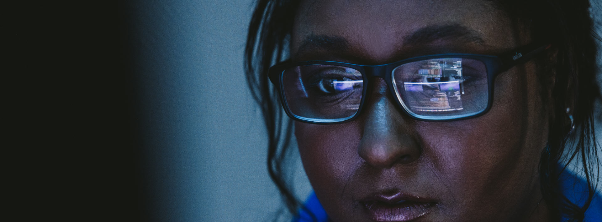 Closeup of a woman wearing glasses looks at a computer screen