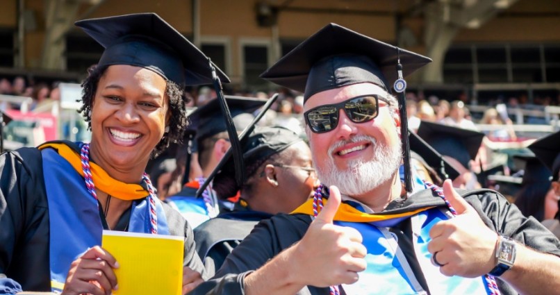 national university graduates giving the thumbs up sign