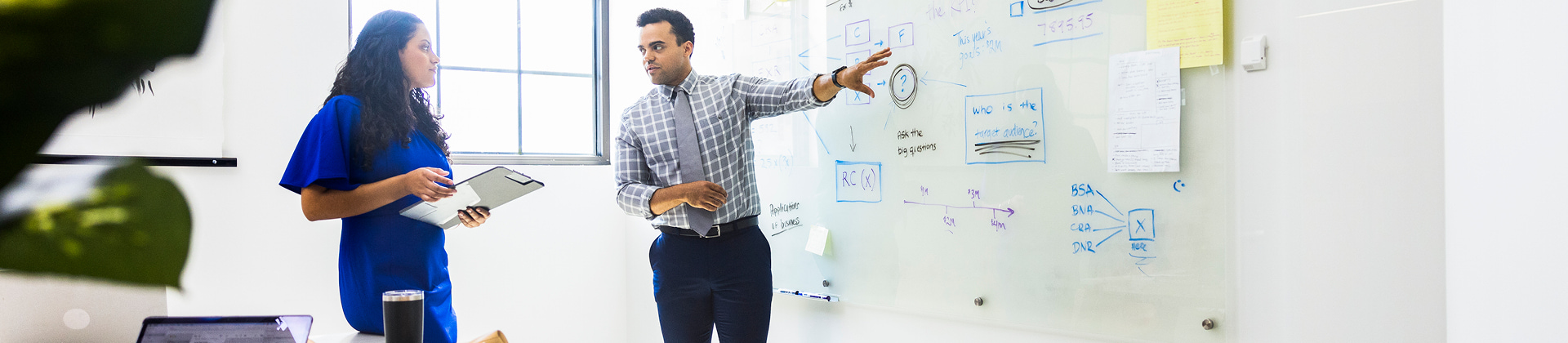 two people working on whiteboard together