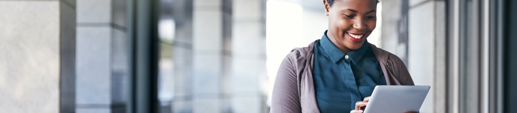 woman smiling and looking tablet