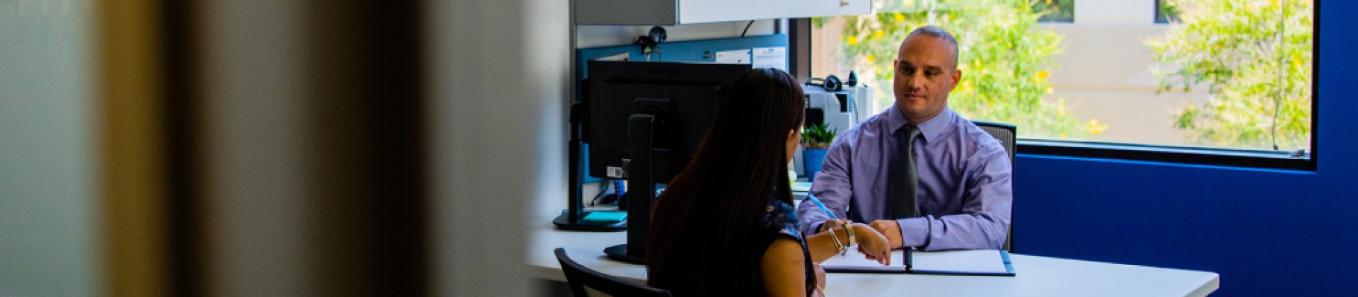 two people chatting in their office about San Diego MBA Graduates