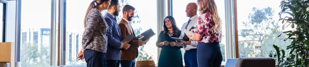 Group of people standing in circle chatting in office