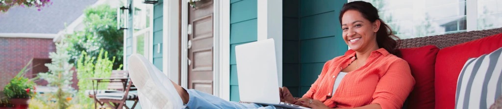 woman sitting on her porch with a laptop