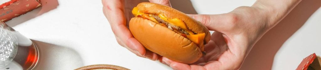 close up of a person's hands holding a burger