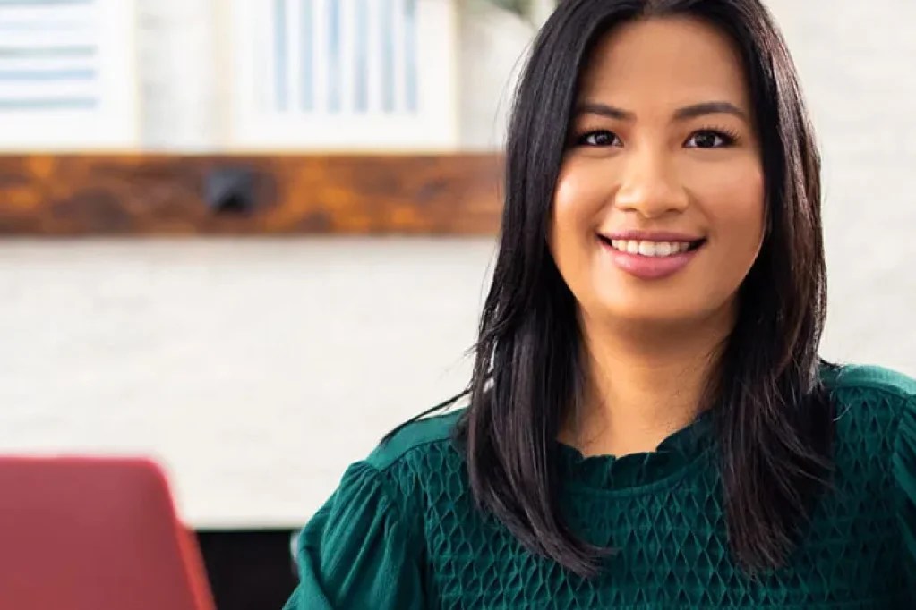 professionally dressed woman sits in an office