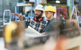 two people in hard hats standing in a warehouse