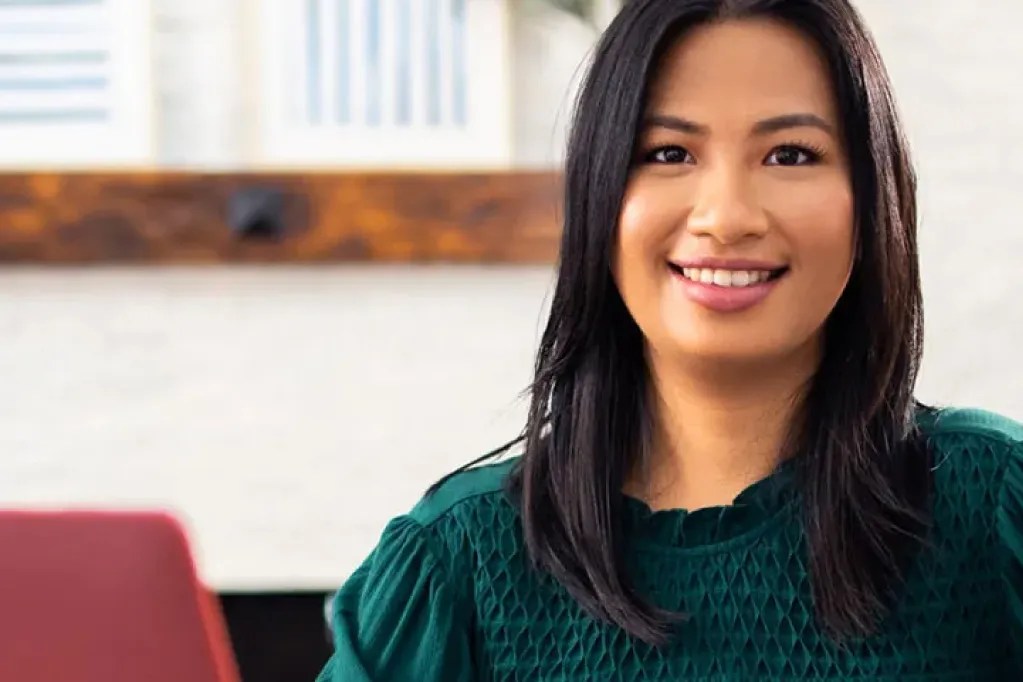 professionally dressed woman sits in an office