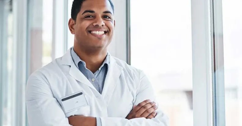 doctor in a white lab coat stands in a hospital