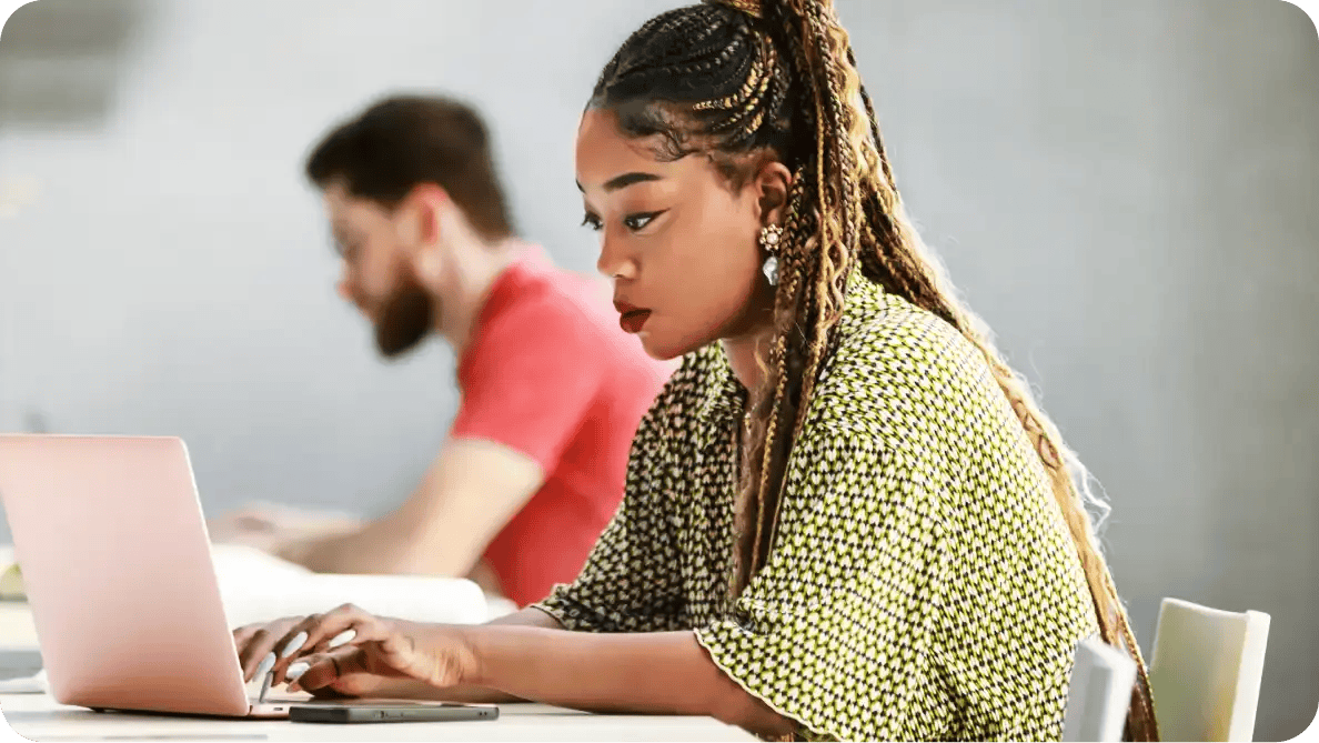 two NU students working on laptops in computer lab