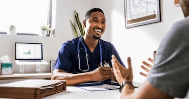 nurse sitting at desk talking to patient