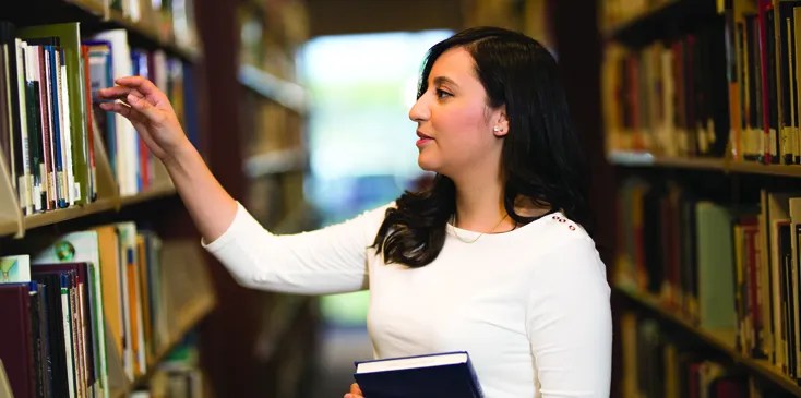 woman in library looking for a book
